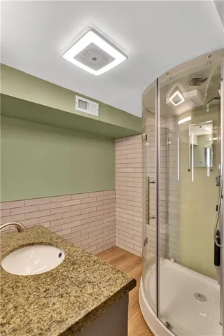 a bathroom with a granite countertop sink toilet and shower