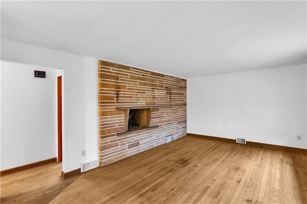 138 Sunset Lane Aliquippa, PA 15001 - Photo 4 of 31 a view of an empty room with wooden floor and a fireplace