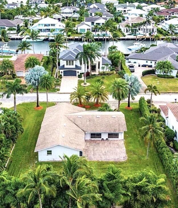 an aerial view of a house with a garden and lake view