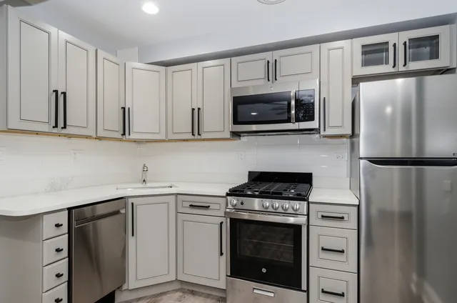 a kitchen with cabinets stainless steel appliances and a counter space