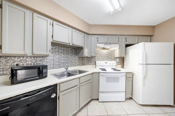a kitchen with appliances a sink and cabinets