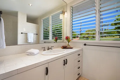 a bathroom with a granite countertop sink and a large mirror