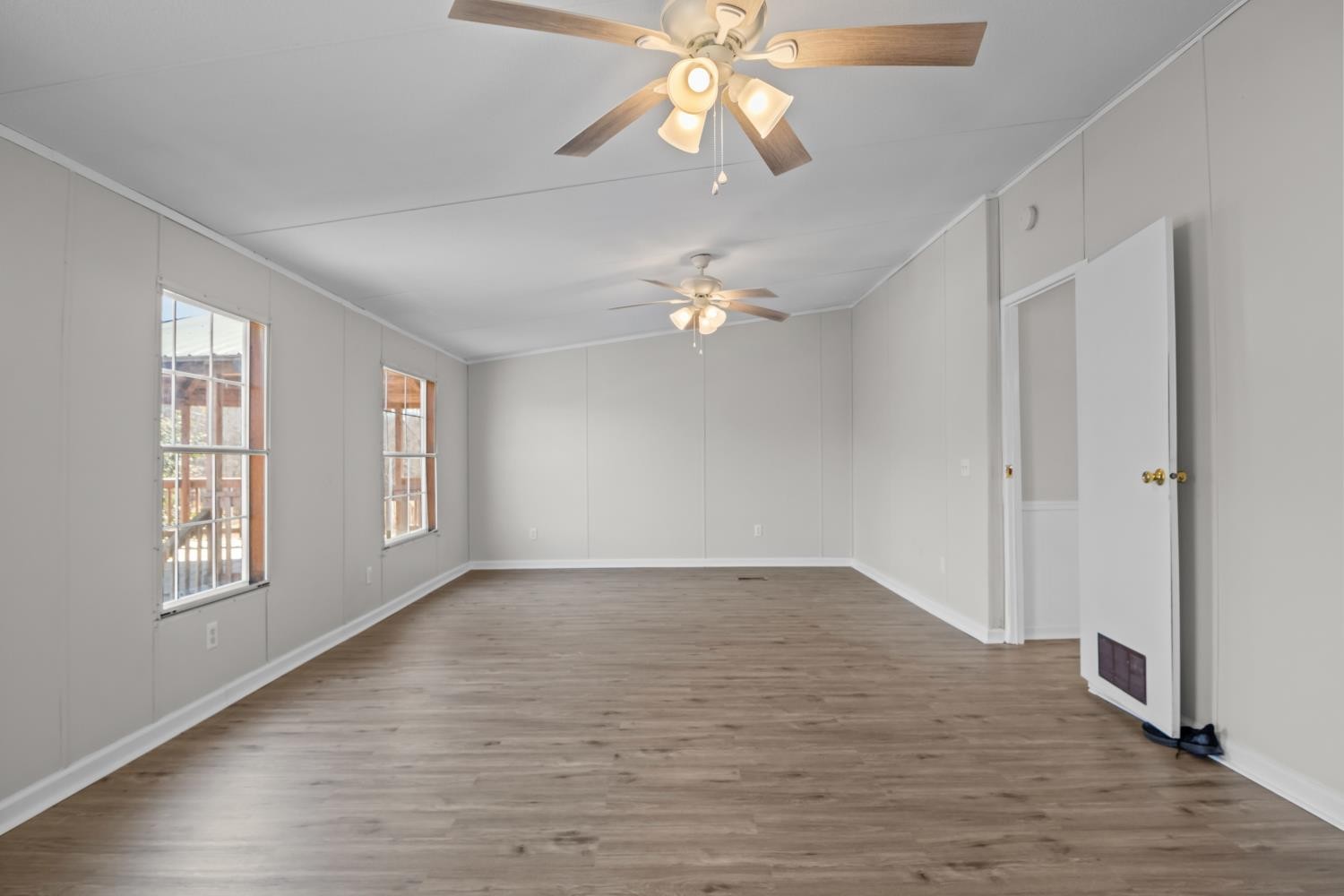 624 Nickletown Road Sugar Tree, TN 38380 - Photo 23 of 45 an empty room with wooden floor chandelier fan and windows