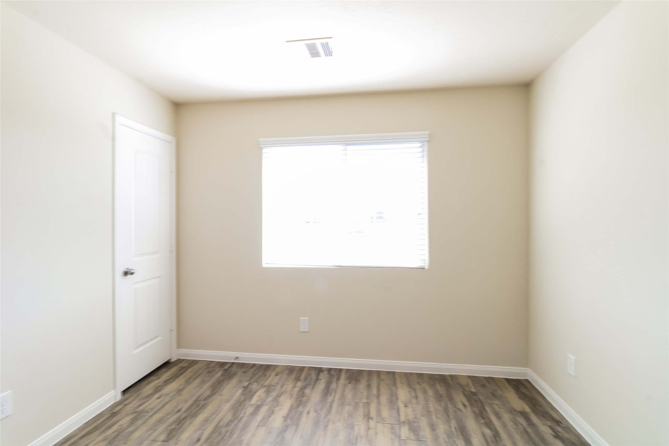12419 Gemma Lane Houston, TX 77044 - Photo 9 of 15 an empty room with wooden floor and windows