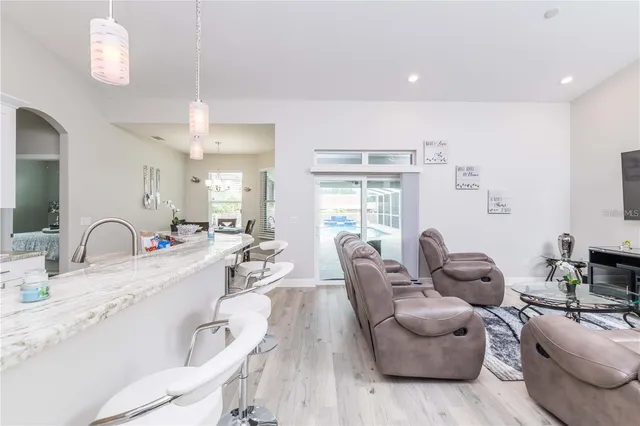 a living room with furniture kitchen view and a large window