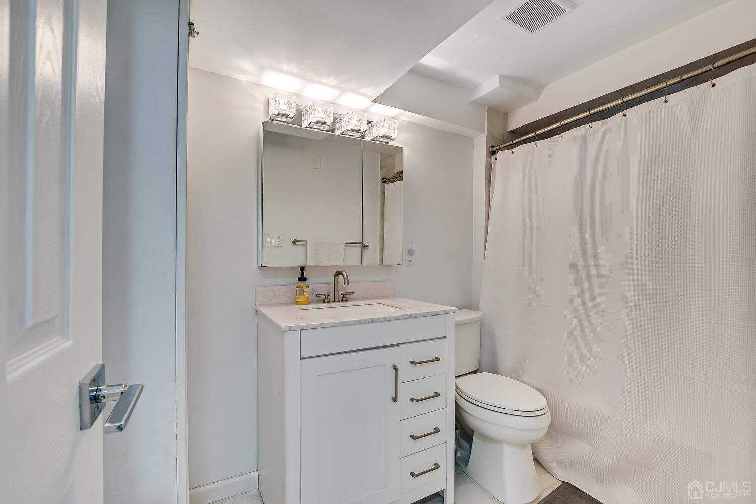12 Eardley Road Edison, NJ 08817 - Photo 31 of 36 a bathroom with a toilet a sink and a mirror
