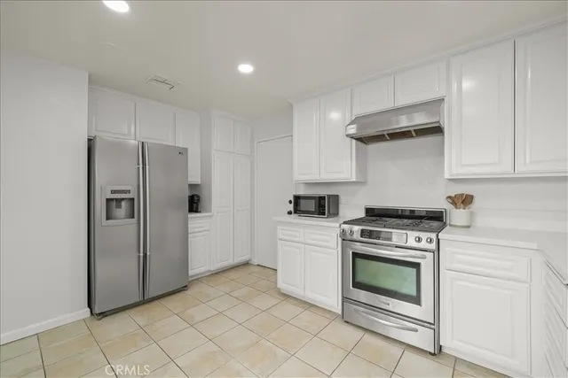 a kitchen with white cabinets and sink