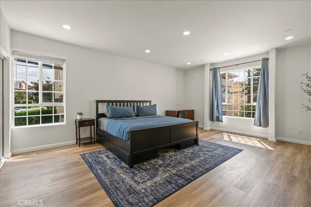 a spacious bedroom with a bed a table and a dresser