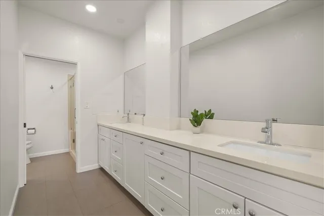 a spacious bathroom with a double vanity sink and mirror