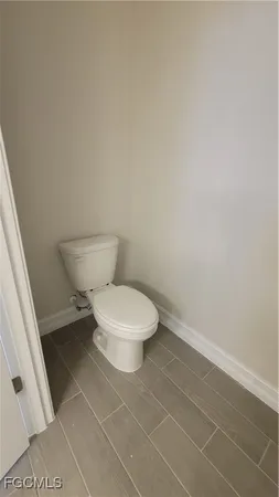 a white toilet sitting next to a white sink and vanity