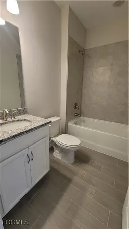 a bathroom with a granite countertop toilet a sink and a bathtub