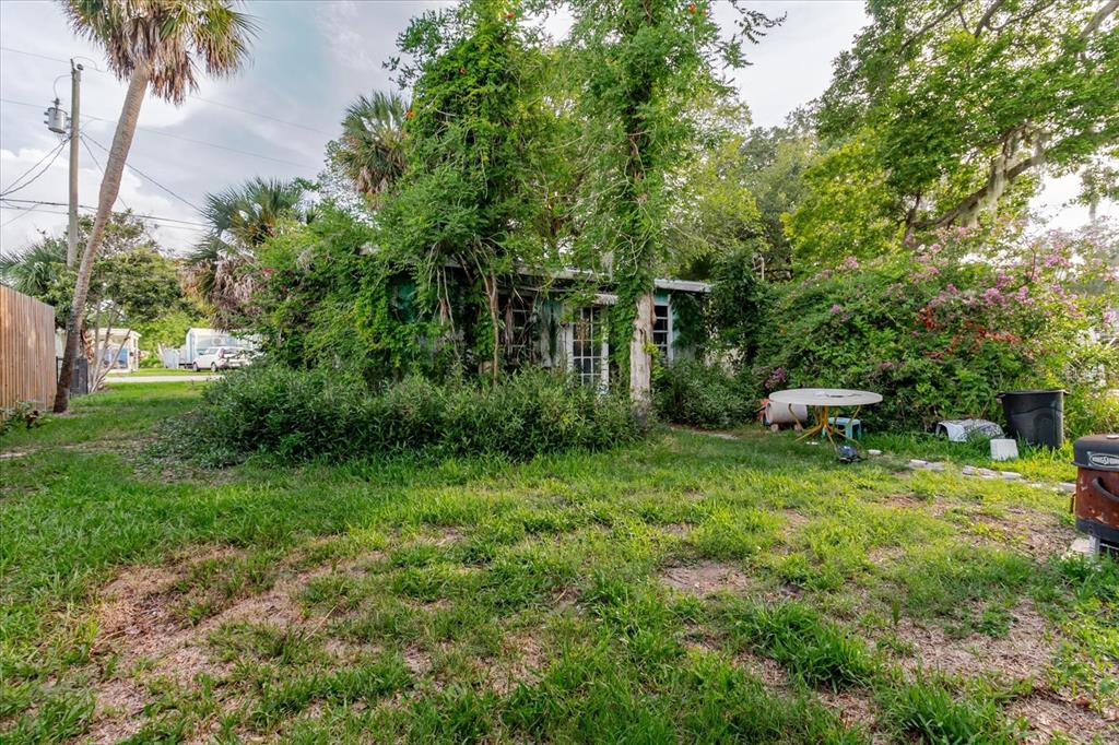 5323 Circle Drive Weeki Wachee, FL 34607 - Photo 57 of 77 a backyard of a house with table and chairs potted plants and large tree