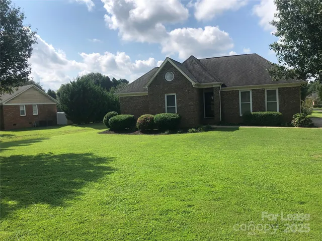 a front view of a house with yard and green space