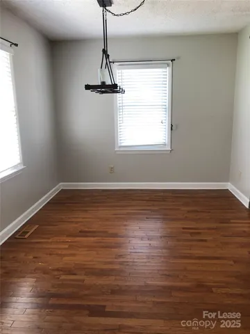 a view of room with window and wooden floor