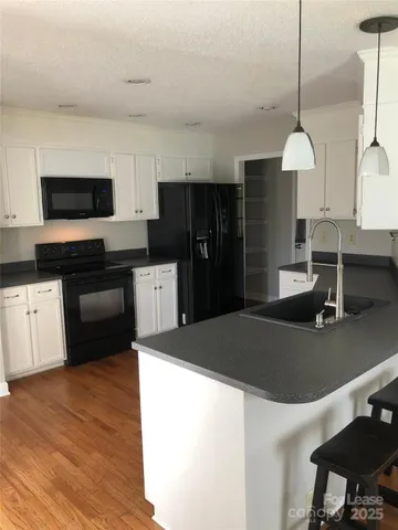 a kitchen with kitchen island a stove a sink and a refrigerator