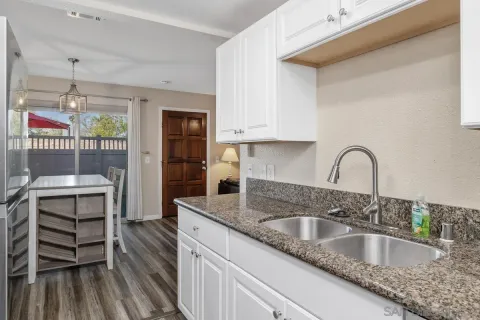 a kitchen with granite countertop a sink and a stove top oven