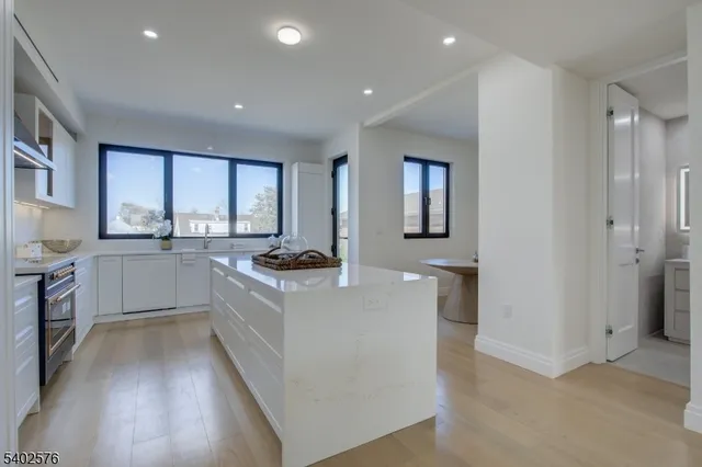 a large kitchen with stainless steel appliances granite countertop a lot of counter space and a sink