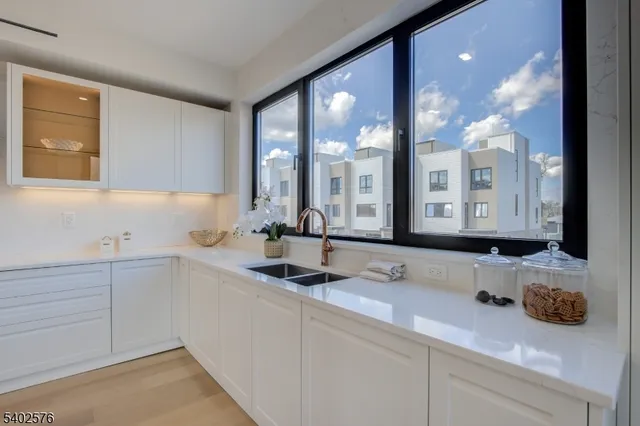 a kitchen that has a sink a stove and cabinets