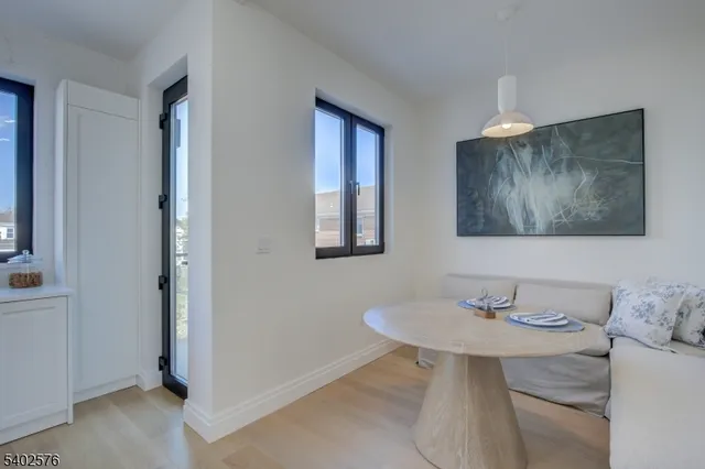 a kitchen with a stove a refrigerator and a dining table with wooden floor