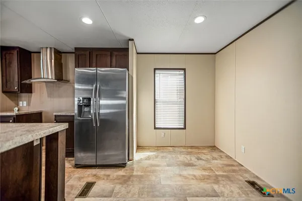 a kitchen with stainless steel appliances granite countertop a refrigerator a sink and a stove