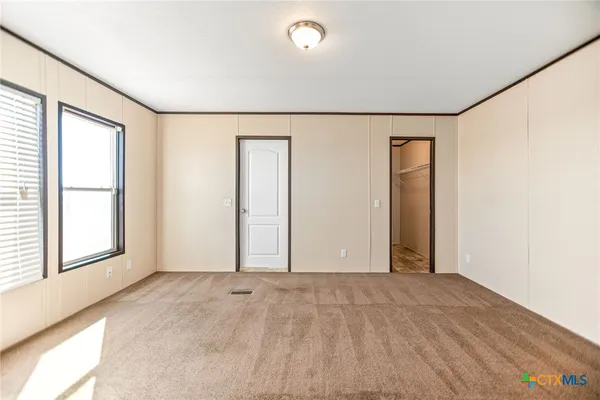 an empty room with windows and closet