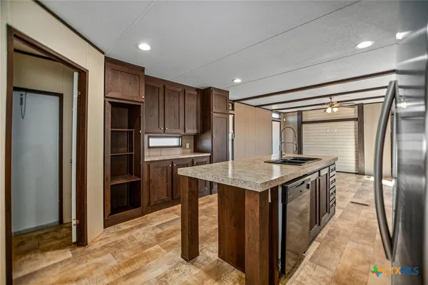 a kitchen with kitchen island stainless steel appliances a sink stove and refrigerator