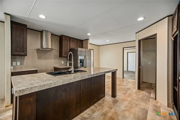 a kitchen with kitchen island granite countertop a sink stove and refrigerator