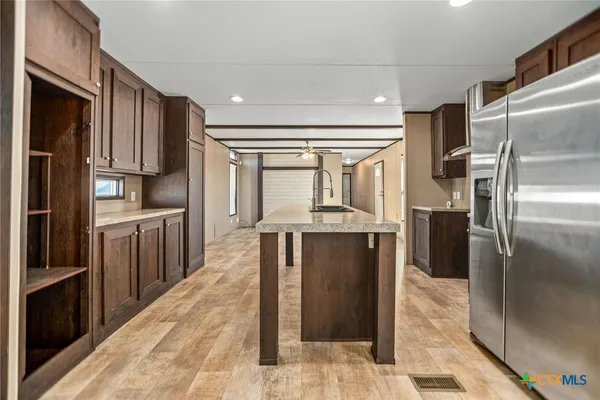 a kitchen with stainless steel appliances granite countertop a refrigerator a stove and a sink