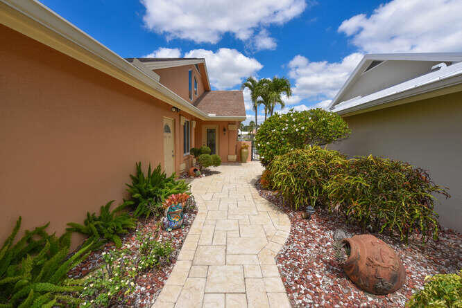 150 Beach Summit Court Jupiter, FL 33477 - Photo 22 of 31 Lush landscaping and paver brick walkway