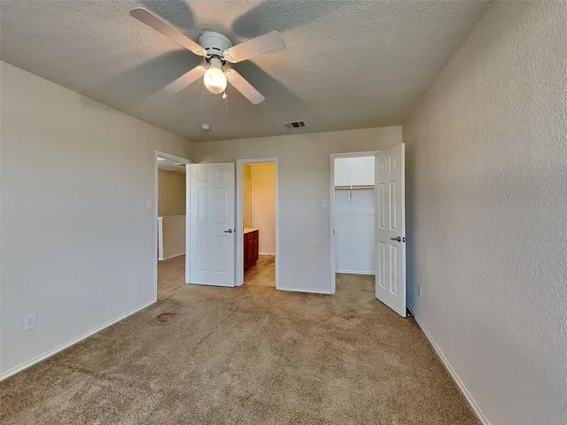 an empty room with fan and entrance