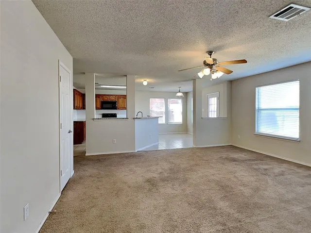 an empty room with windows and fireplace
