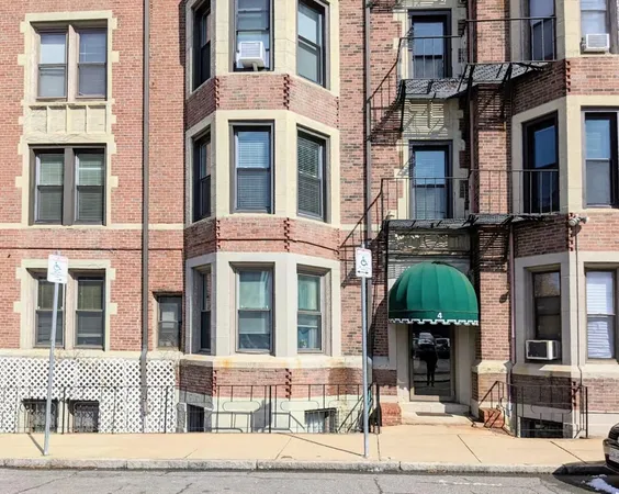 a front view of a residential apartment building with a yard