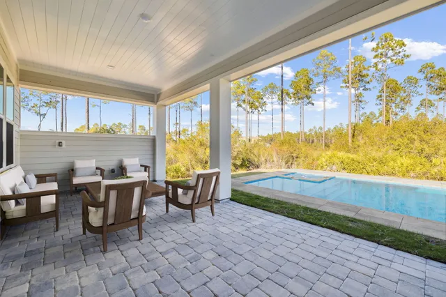 a view of a kitchen with kitchen island a sink wooden floor and a refrigerator