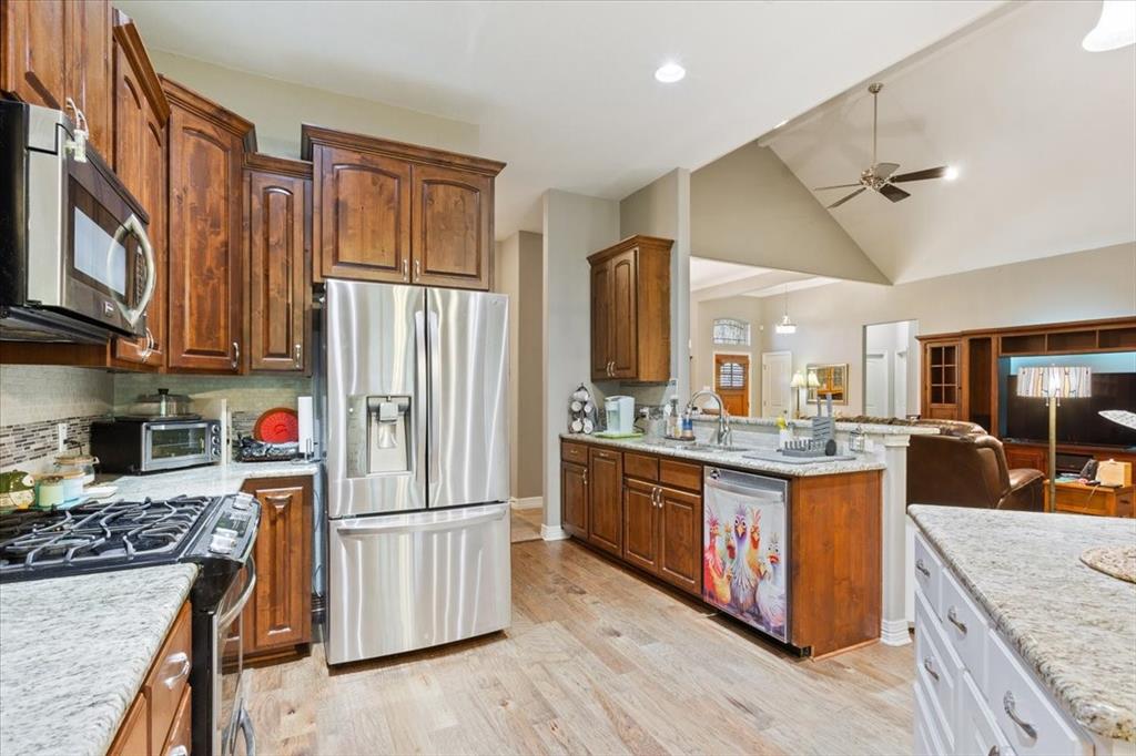 128 Creek Ridge Drive Waco, TX 76708 - Photo 40 of 40 Kitchen featuring appliances with stainless steel finishes, ceiling fan, open floor plan, a sink, and decorative backsplash