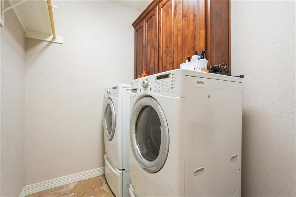 128 Creek Ridge Drive Waco, TX 76708 - Photo 32 of 40 Clothes washing area with washing machine and clothes dryer, cabinet space, and baseboards