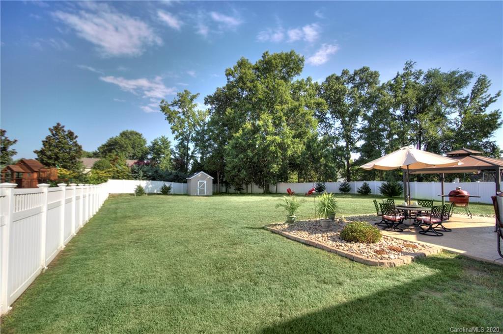 7029 Meyer Road Fort Mill, SC 29715 - Photo 36 of 42 a view of a patio with table and chairs under an umbrella