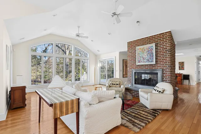 a living room with furniture fireplace and a large window