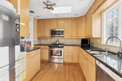 a kitchen with stainless steel appliances a sink a stove a microwave and cabinets