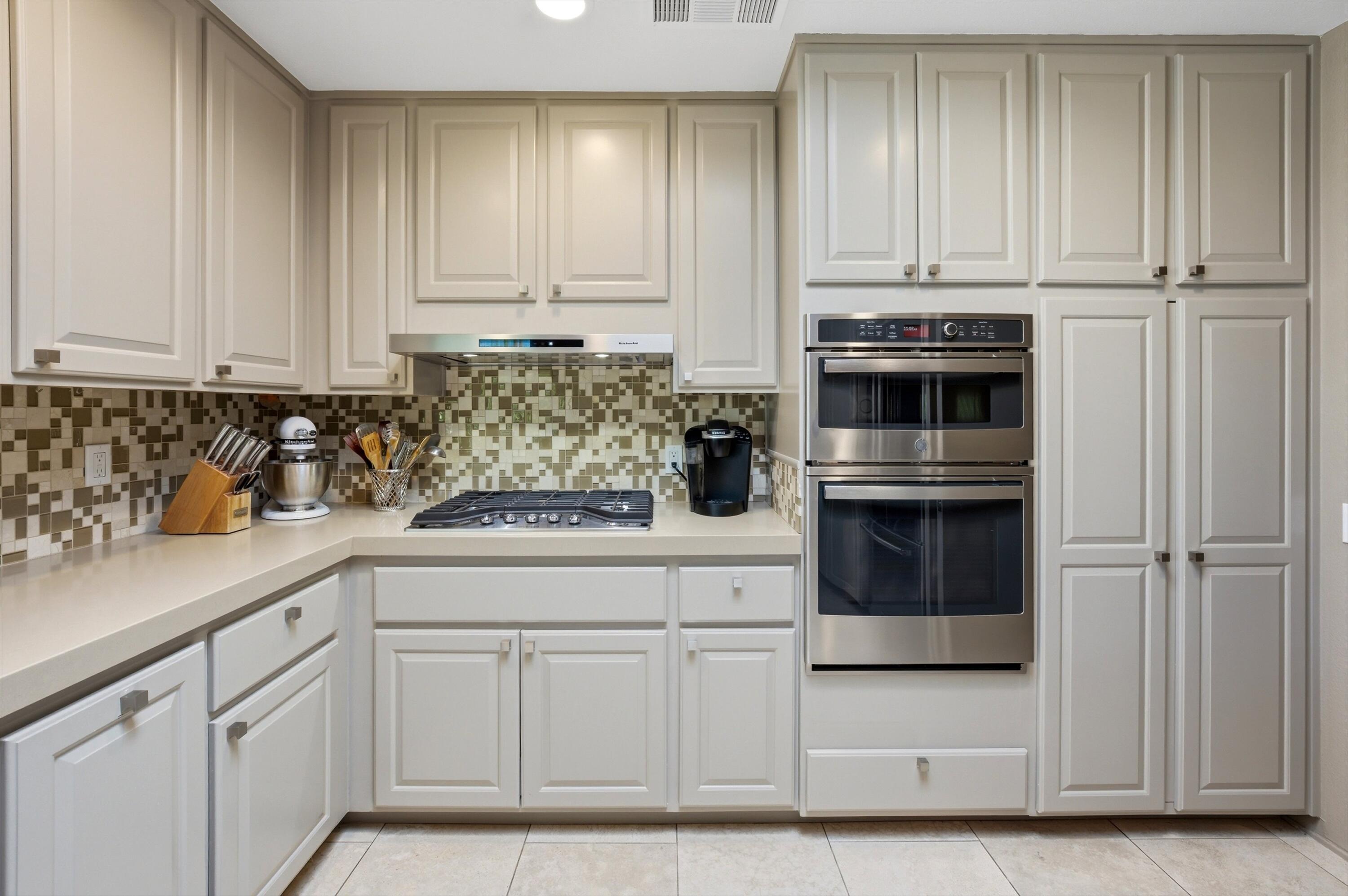 3 Barnard Court Rancho Mirage, CA 92270 - Photo 12 of 47 a kitchen with white cabinets and white appliances