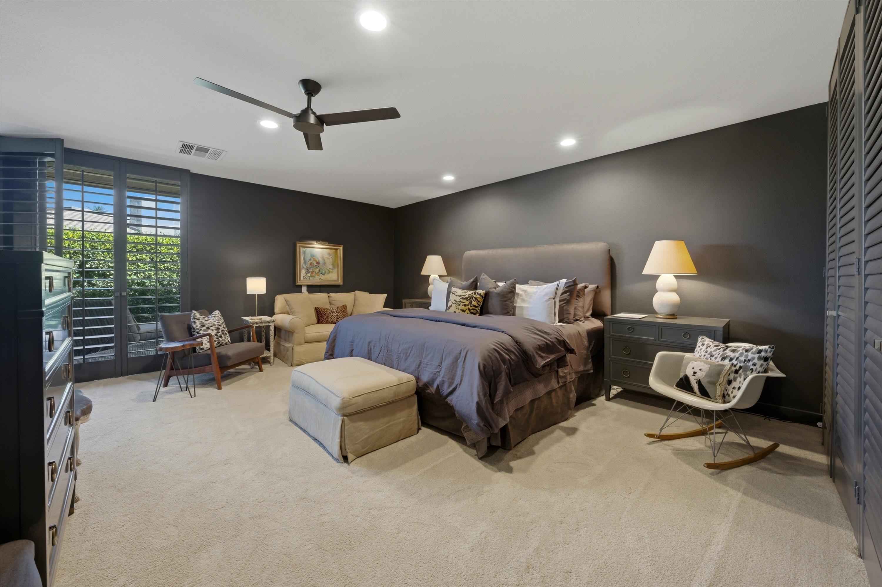 3 Barnard Court Rancho Mirage, CA 92270 - Photo 19 of 47 a spacious bedroom with a bed and a chandelier