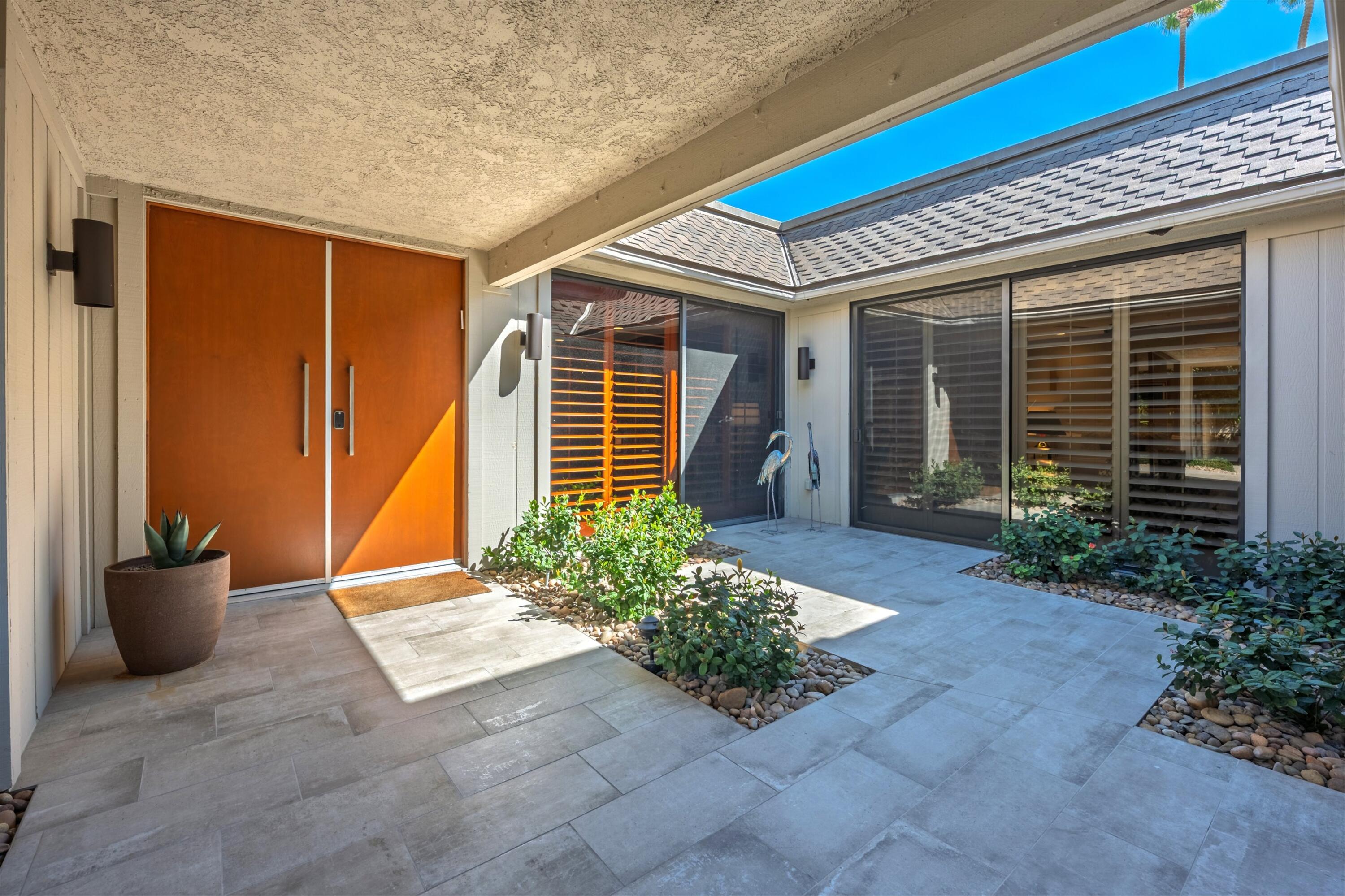 3 Barnard Court Rancho Mirage, CA 92270 - Photo 4 of 47 a front view of a house with potted plants