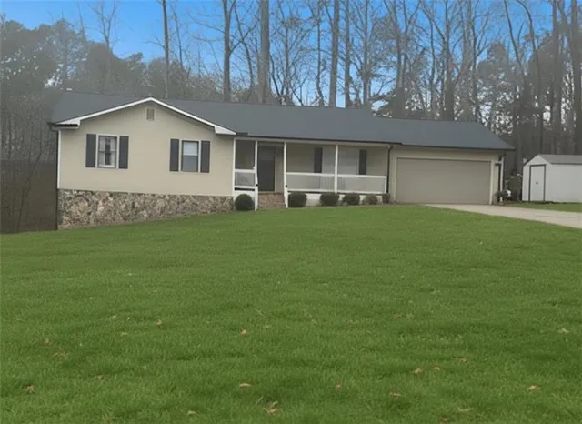a view of a house with a yard and sitting area