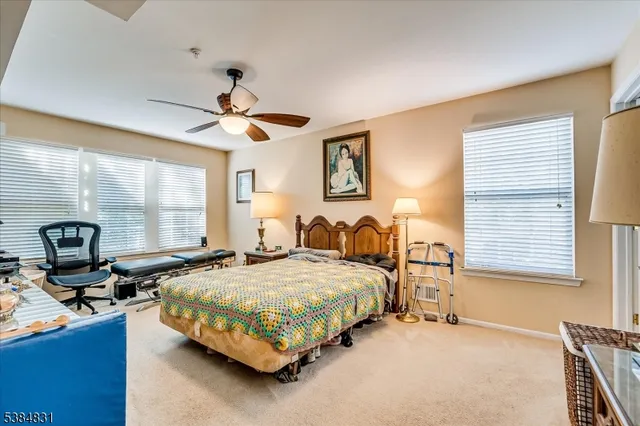 a bedroom with a bed a chandelier and dresser