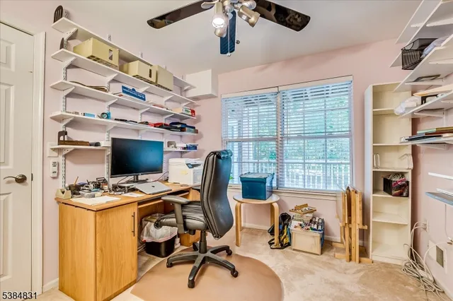 a view of a workspace with furniture and a window
