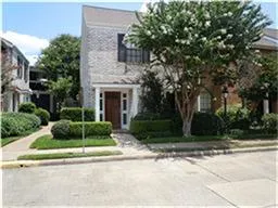 a front view of a house with a yard and potted plants