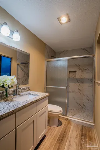 a bathroom with a granite countertop sink toilet and shower