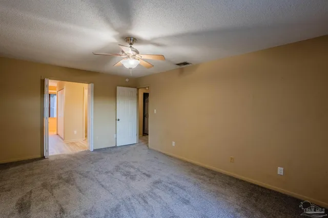 a view of an empty room with a ceiling fan