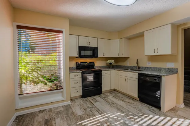 a kitchen with a stove a sink and a microwave