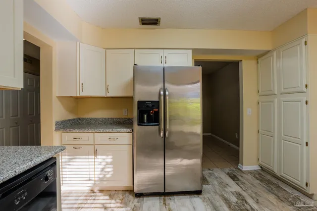 a kitchen with granite countertop a refrigerator and a sink