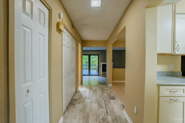 a view of a hallway with wooden floor and cabinet